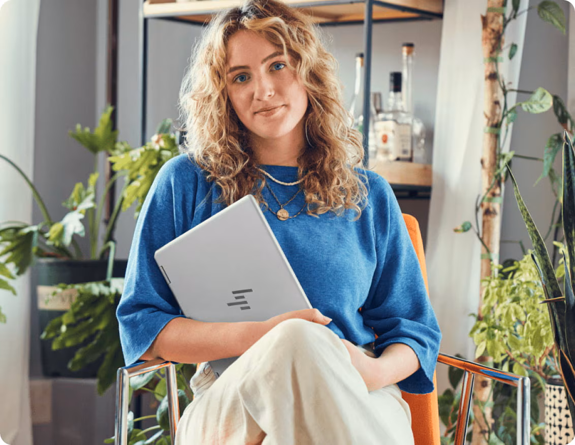 Woman working with an HP laptop in a garden.